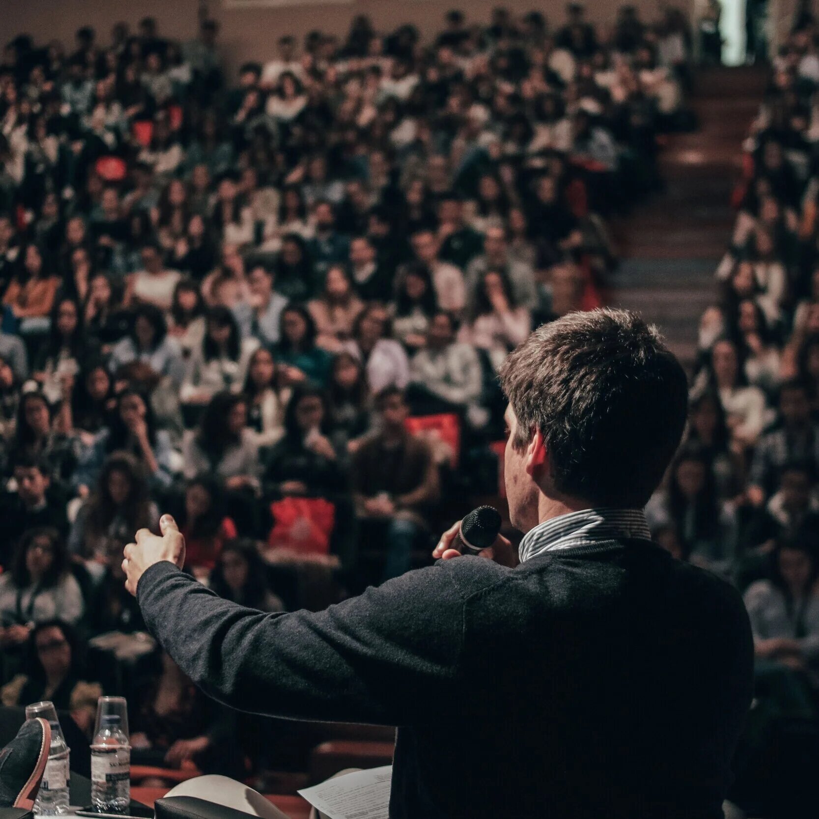 Speaker presenting on technical hiring to a packed conference auditorium